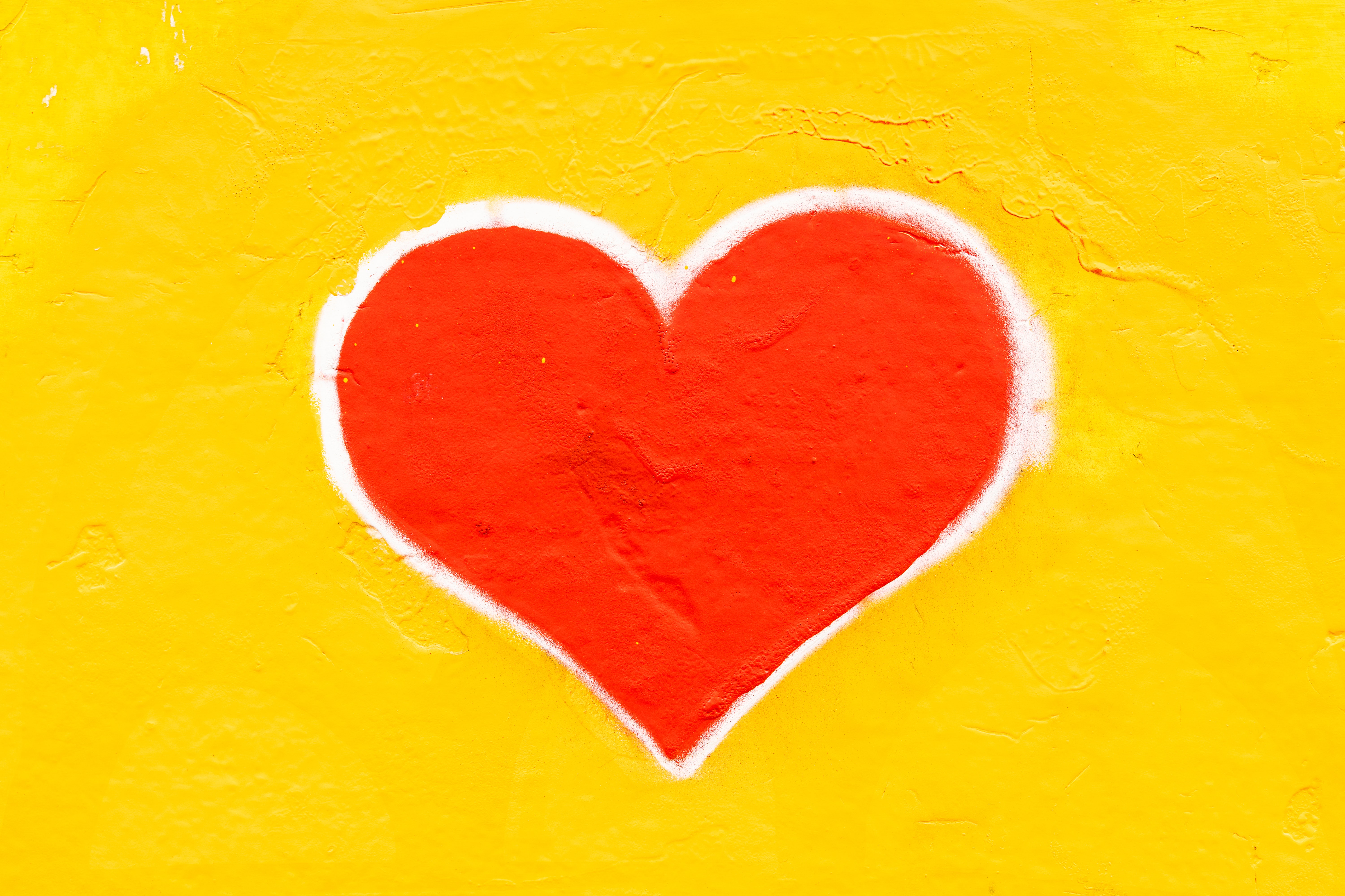 Coeur peint sur un mur jaune